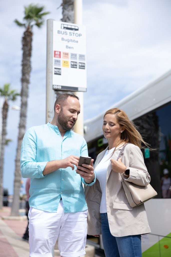 Couple using tallinja app on bus stop
