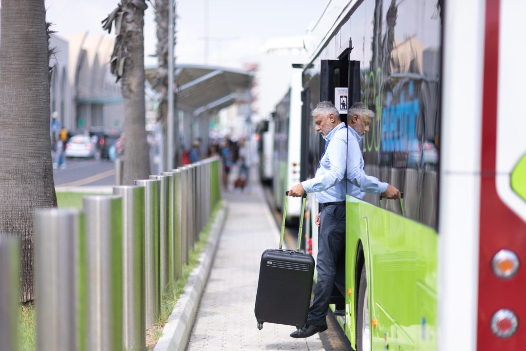 Man disembarking bus with luggage