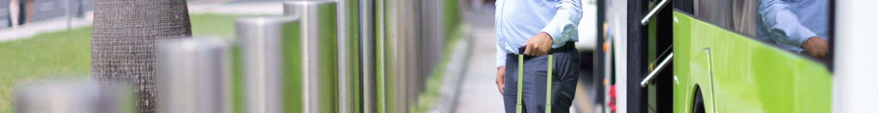 elderly man leaving bus with suitcase towards airport