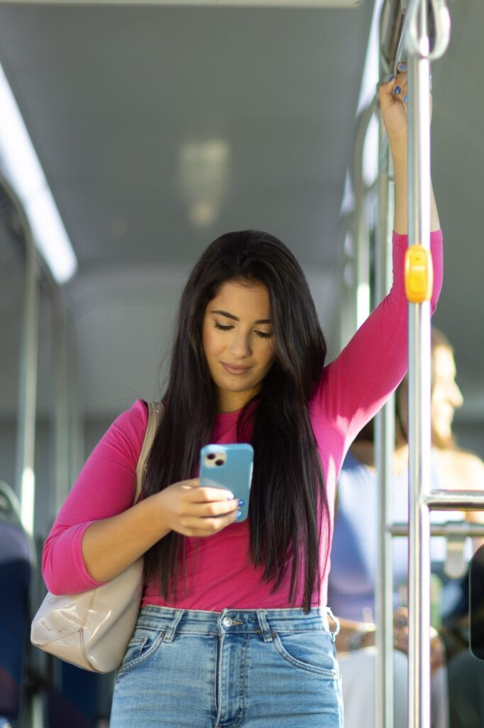 Woman on bus looking at the mobile.